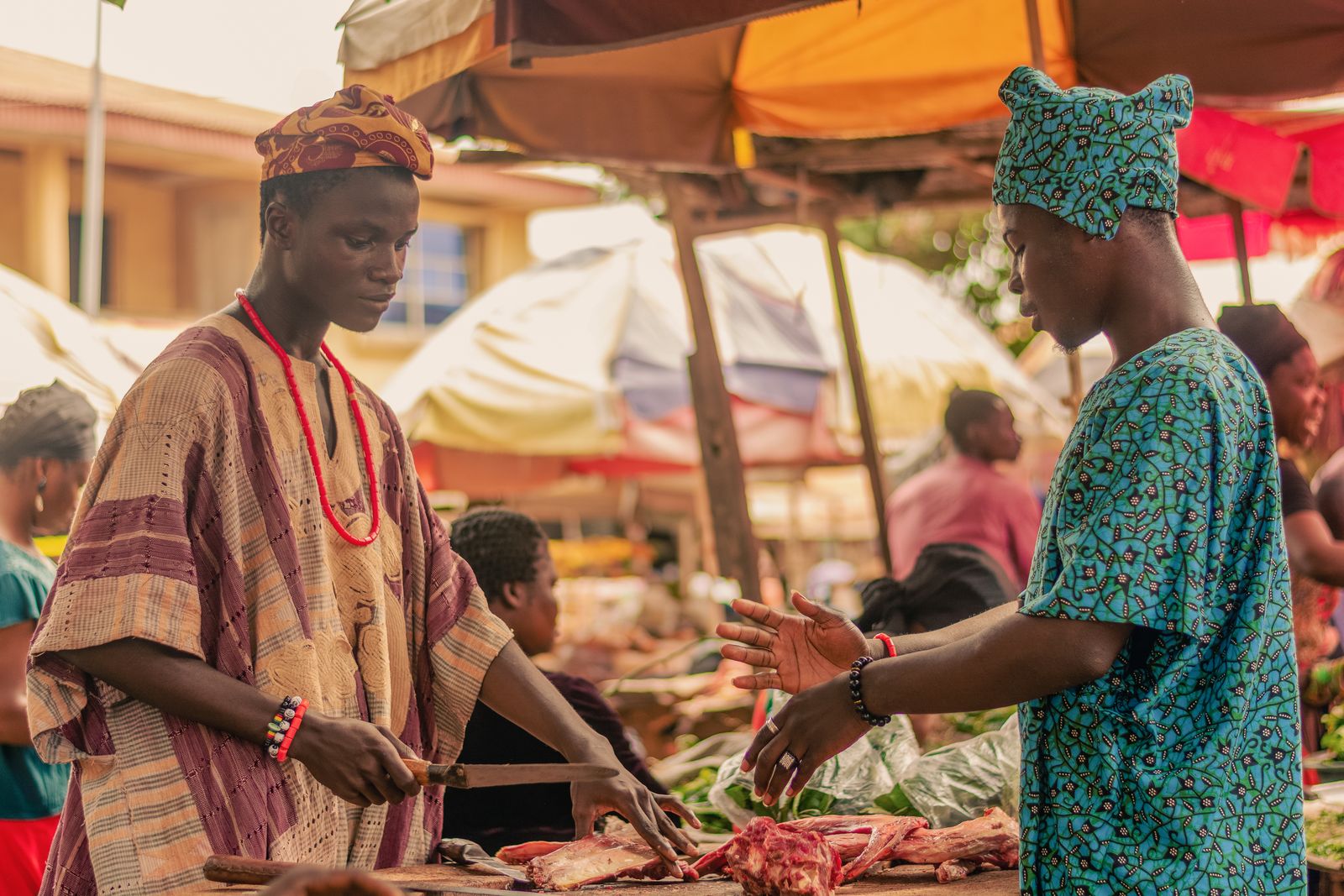 Two West African traders negotiating at a market stall